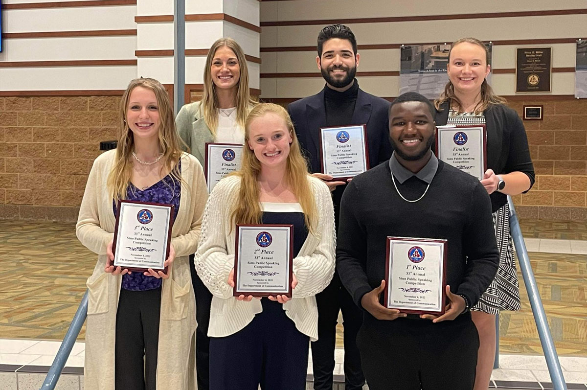 six students posing with award plaques